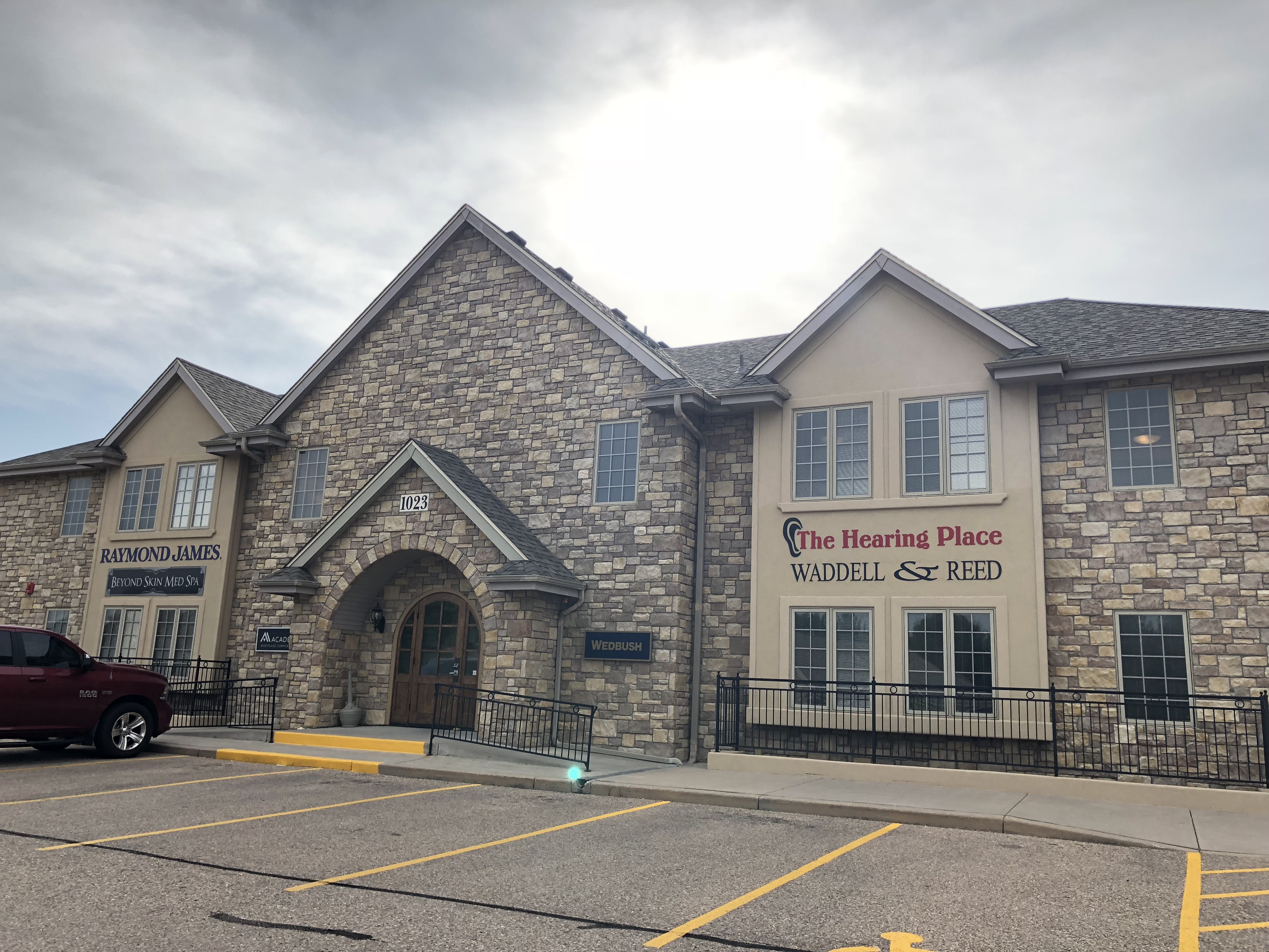 greely-full-image stone building with red sign that reads the hearing place in greeley